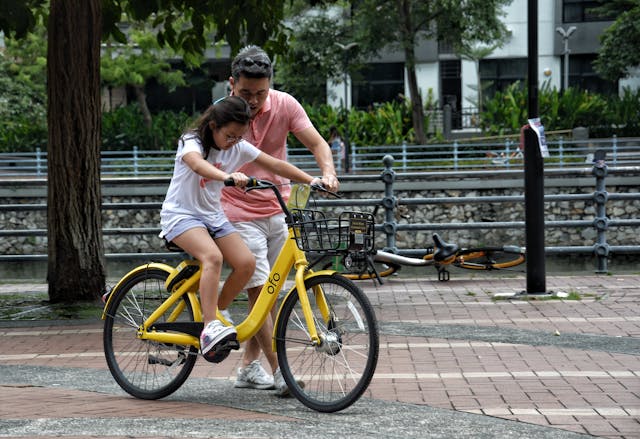 Vader leert dochter fietsen