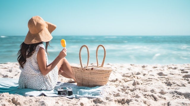 Vrouw met ijsje op het strand